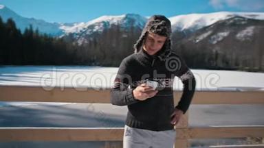 在美丽的山地公园冬天，帅哥使用智能<strong>手机</strong>户外<strong>活动</strong>